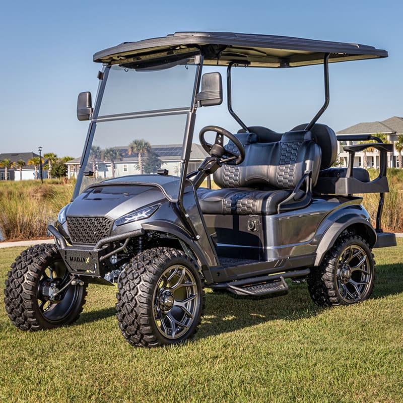 XSeries nerf bars installed on a cart parked in a green lawn with lifted wheels and tires.