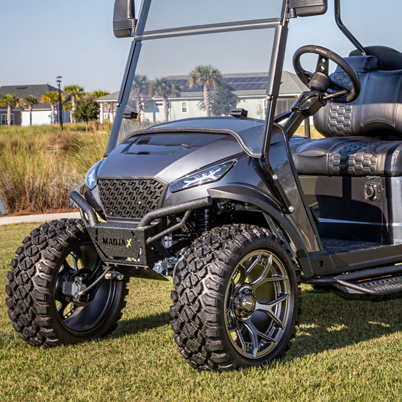 Front Storm powdercoated brush guard installed on charcoal colored 2024 model X2 golf cart, parked on grass near residential neighborhood.