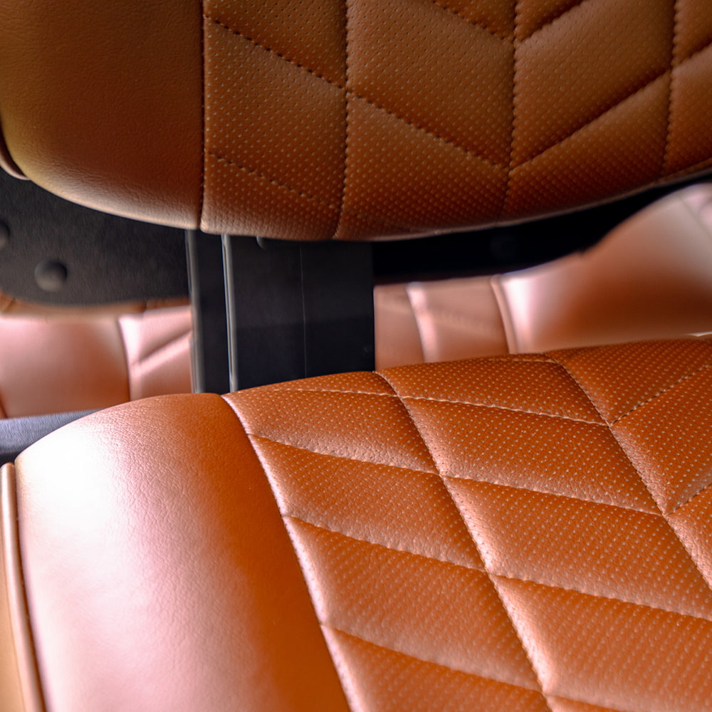 Close up detailed view of the premium marine grade vinyl used on the Aviator line of golf cart seat cushions, displaying the stitching details and perforated vinyl inset design engineered to withstand the elements for long life, for sale by Salt City Golf Cart in Hutchinson, Kansas.