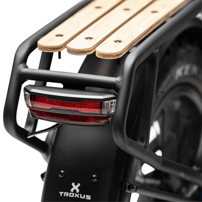 Close up view of the manufacturing details and integrated LED brake light on the rear alloy cargo rack of the Lynx ebike.